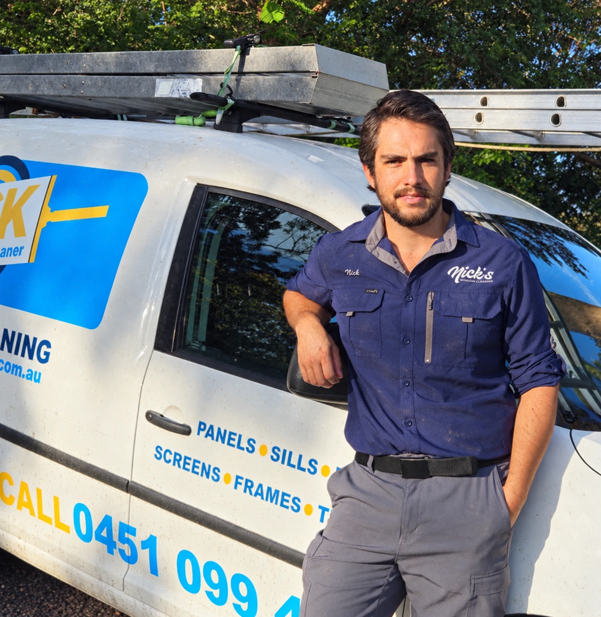 Nick, owner of Nickโs Window Cleaning, beside his work van in Brisbane