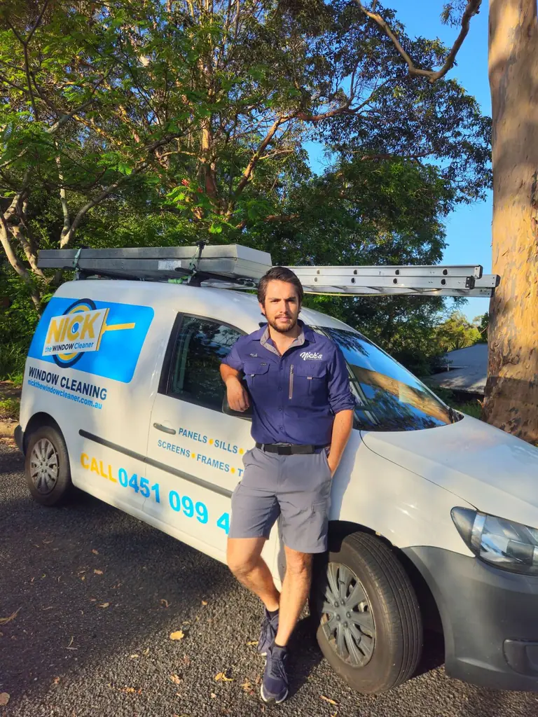 Nick's Window Cleaning technician standing beside the company van